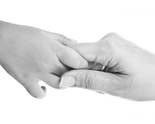Closeup of giving a helping hand to another. isolated on white background